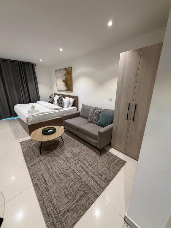 a living room with a couch and a coffee table at Spacious Studio Apt Airport Residential in Accra