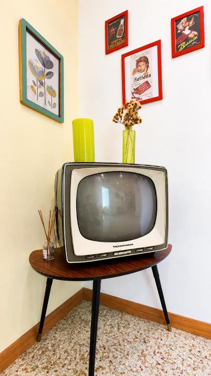 a television sitting on a table with a vase on it at San Felice Central Room in Bologna