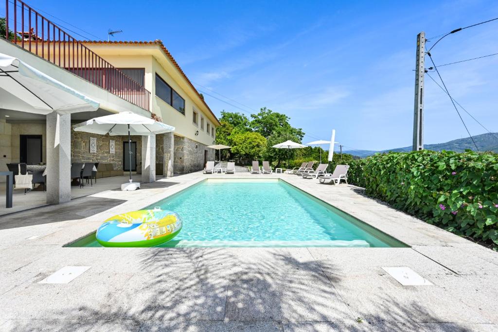 a swimming pool with a toy boat next to a house at Casa da Galheira with Swimming Pool by Sé Apartamentos in Vilela