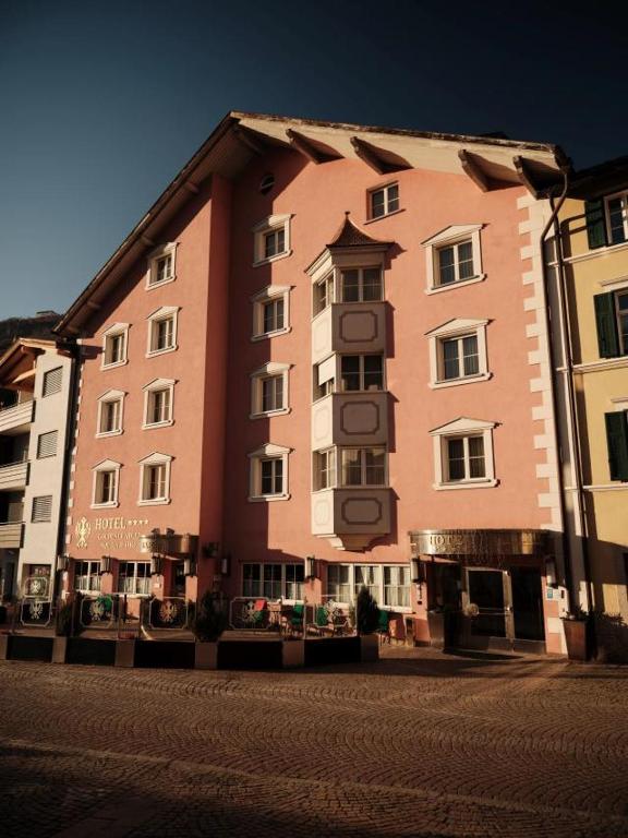 a large building on a street in a city at Cityhotel Goldener Adler B&B in Chiusa