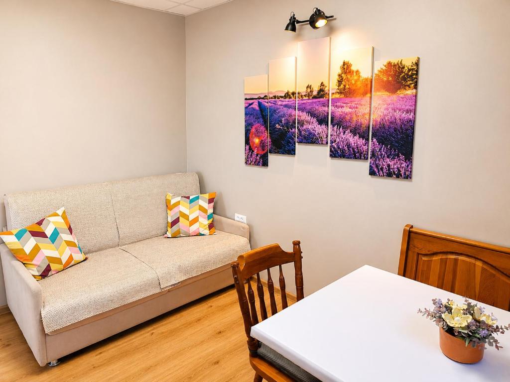 a living room with a couch and paintings on the wall at Solea Apartment in Woditz
