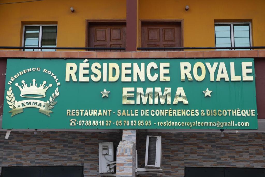 a sign on the side of a building at Résidence Royale Emma in Abidjan