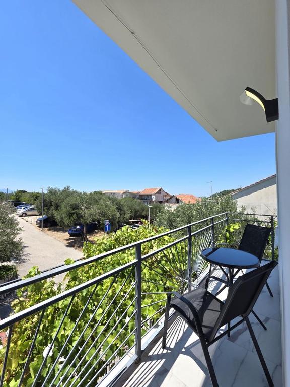 a table and chair on a balcony with a view at Apartments Sunce in Podaca
