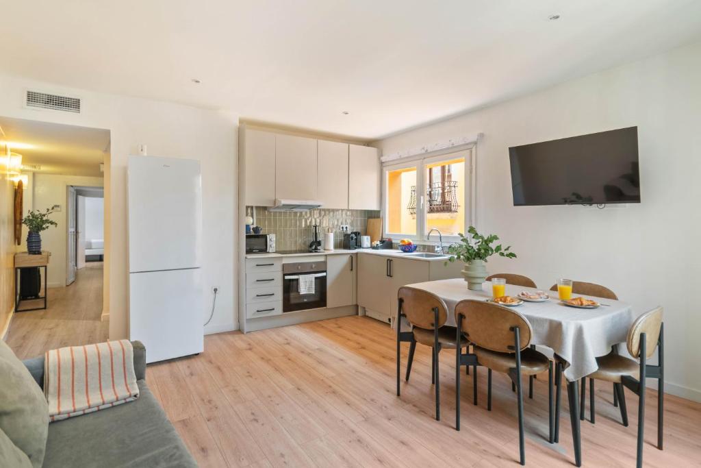 a kitchen and dining room with a table and chairs at Rambla de Mar Apartments by Blossom Hotels in Barcelona