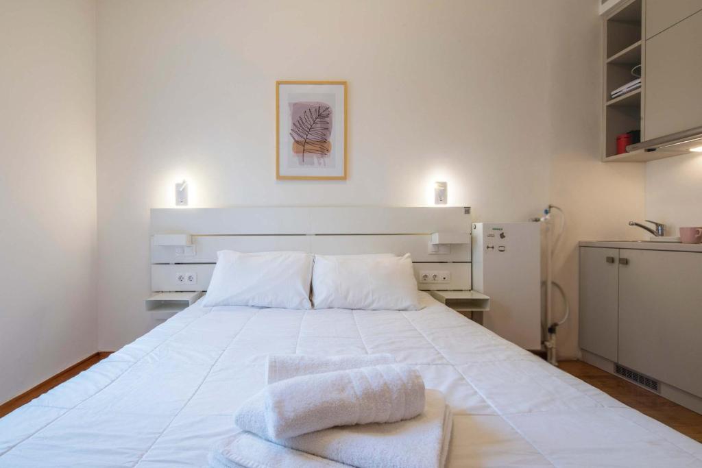 a bedroom with a large white bed with towels on it at Syntagma Gem 2 in Athens
