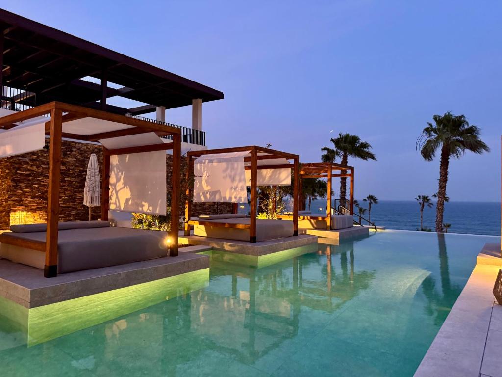 a resort with a pool with the ocean in the background at CocoBeach Mojácar - 3 min a pie de Playa Macenas in Mojácar