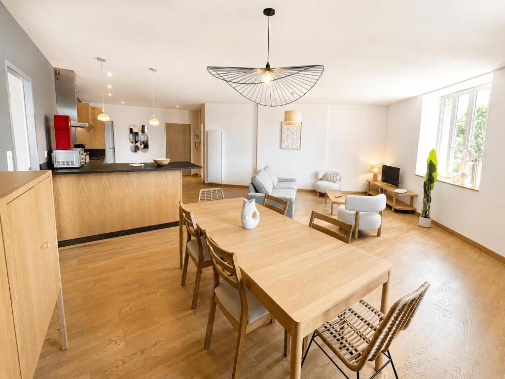 a dining room and living room with a table and chairs at Aux loges du théâtre in Moulins