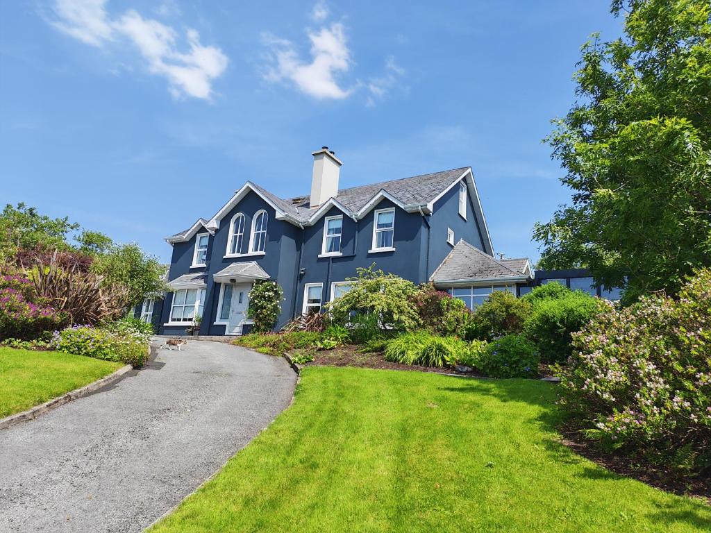 a large blue house with a driveway at Apartments at Ballinsheen House & Gardens in Lisdoonvarna