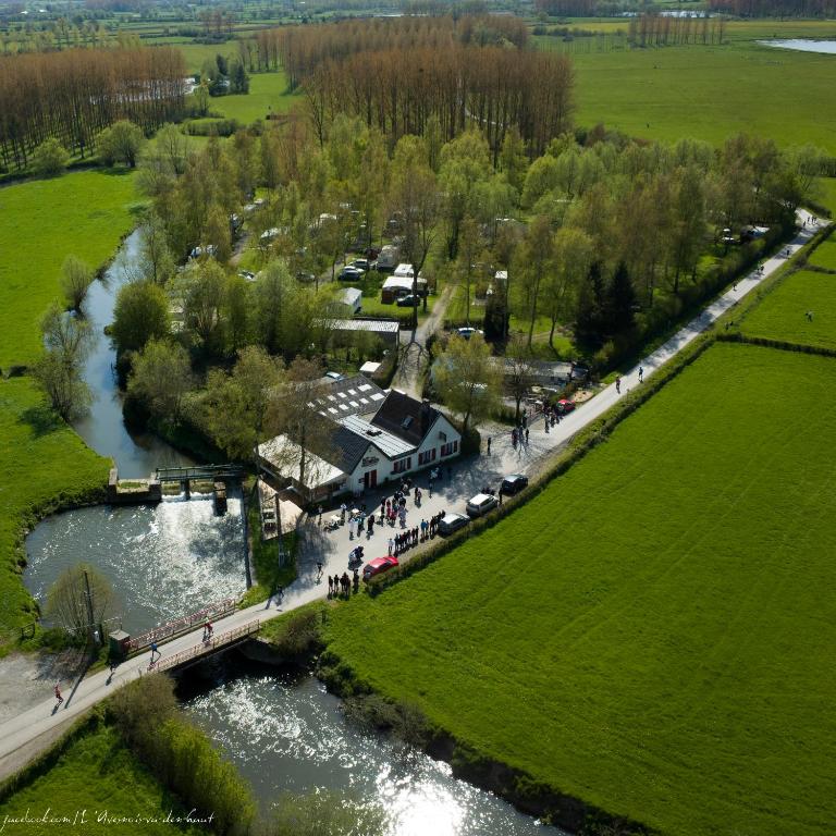 une vue aérienne sur une rivière avec un pont dans l'établissement L'auberge du moulin des prés, à Maroilles
