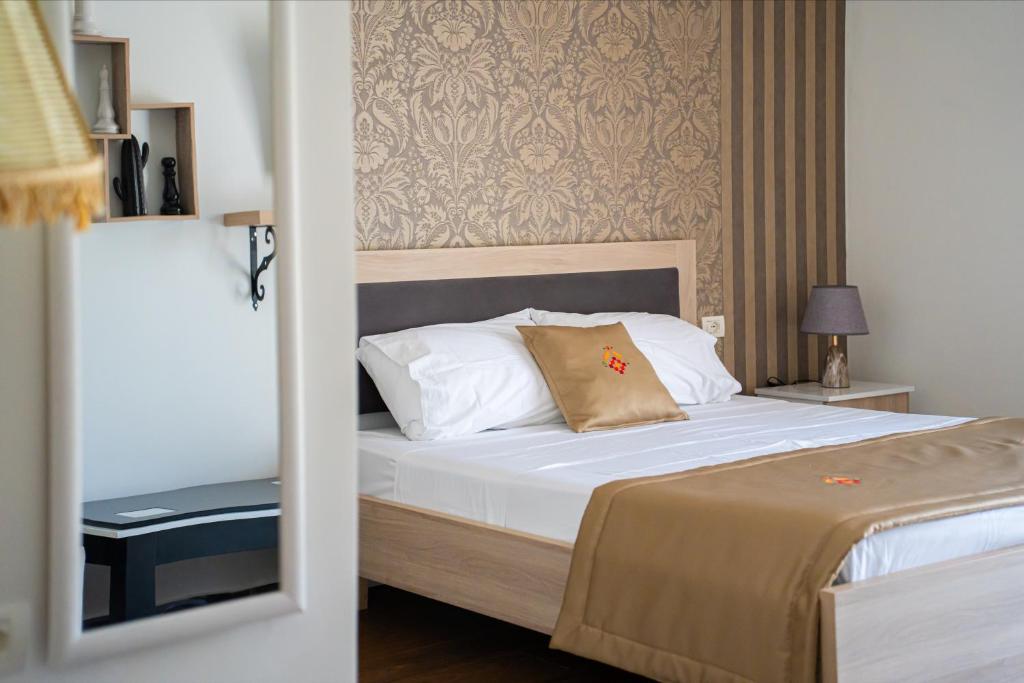 a bedroom with a bed with white pillows at N'Log N'Skuraj Hotel in Ferr -Skuraj