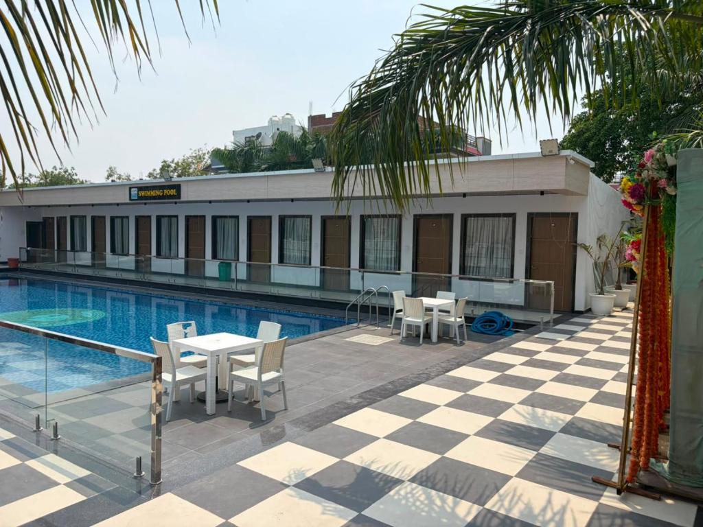 a hotel with a pool and tables and chairs at The Kashi Dharohar in Varanasi