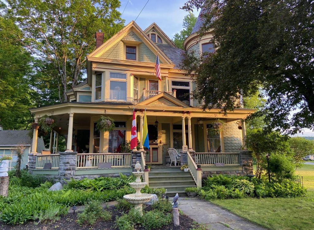 an old house with a flag on the porch at Bentley House Bed and Breakfast in Poultney