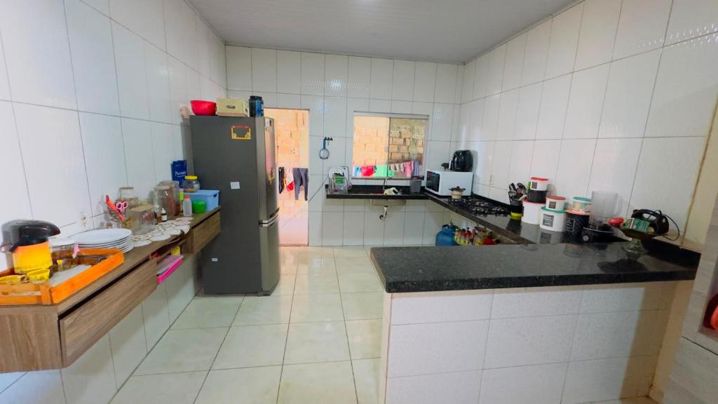 a kitchen with a refrigerator and a counter top at Casa da Daniella in Conceição do Araguaia