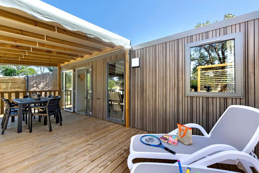 a patio with a table and chairs on a deck at Mobilehome Evasion 54 in Saint-Gervais