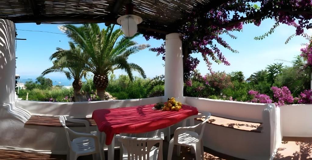 a table and chairs on a patio with a palm tree at Casa Marel in Stromboli