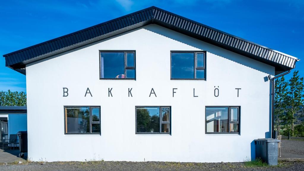 a white building with the words baxter kitchen on it at Bakkaflöt Guesthouse in Varmahlid