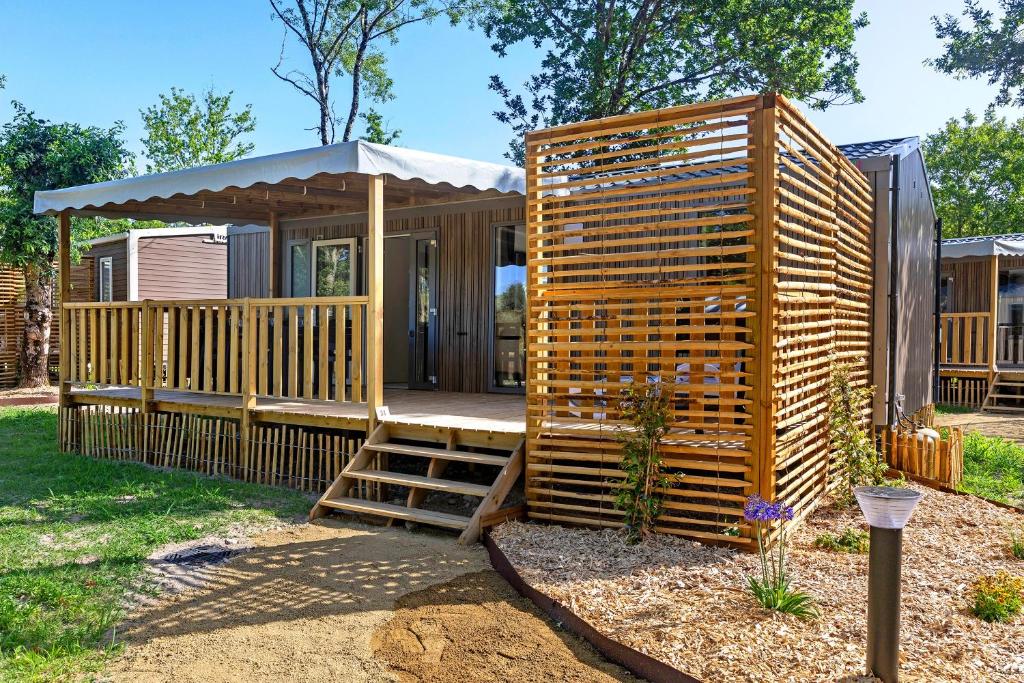 a wooden cabin with a porch and a ladder at Mobilehome Evasion 51 in Saint-Gervais