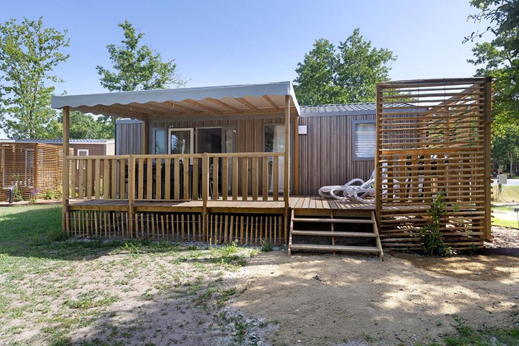 a small cabin with a porch and a deck at Mobilehome Evasion 50 in Saint-Gervais