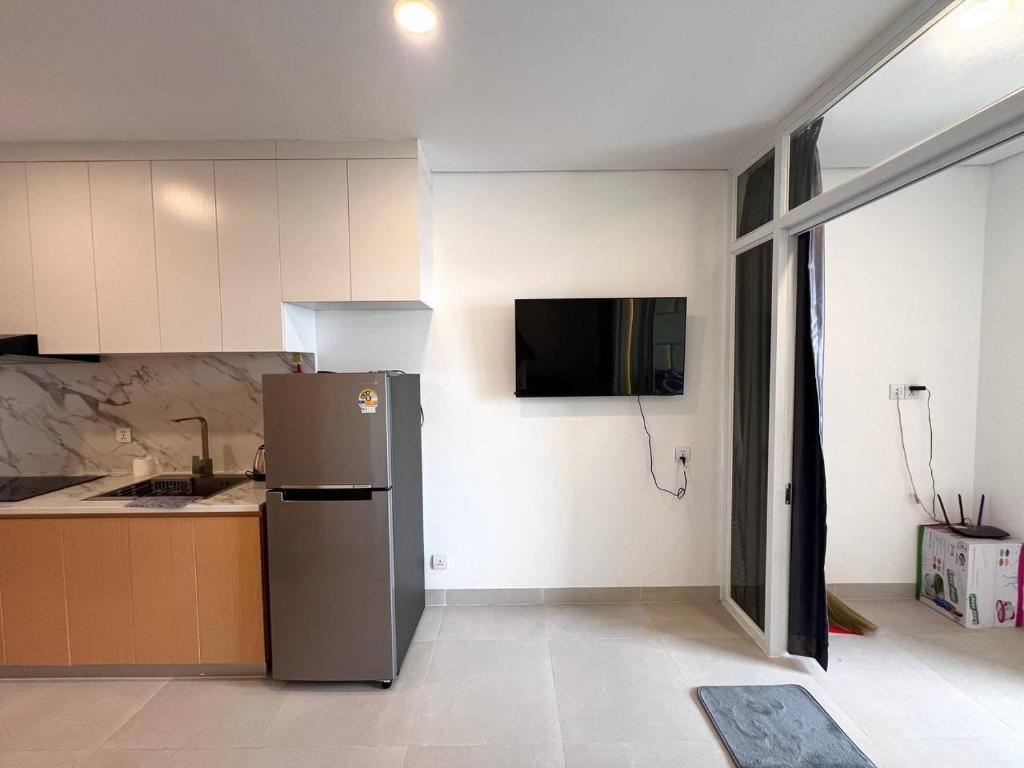 a kitchen with a refrigerator and a tv on the wall at Jitendra Pyakuryal in Kathmandu