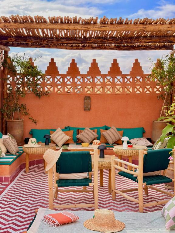 a patio with a couch and tables and chairs at Riad El Badun in Marrakesh