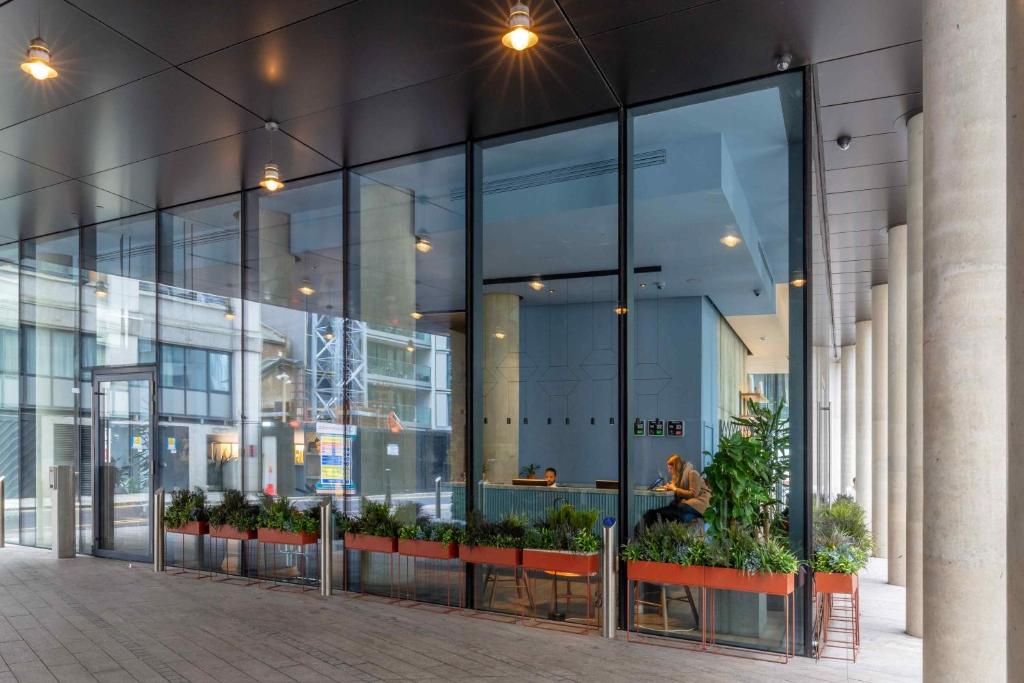a large glass building with plants in front of it at Leman Locke in London