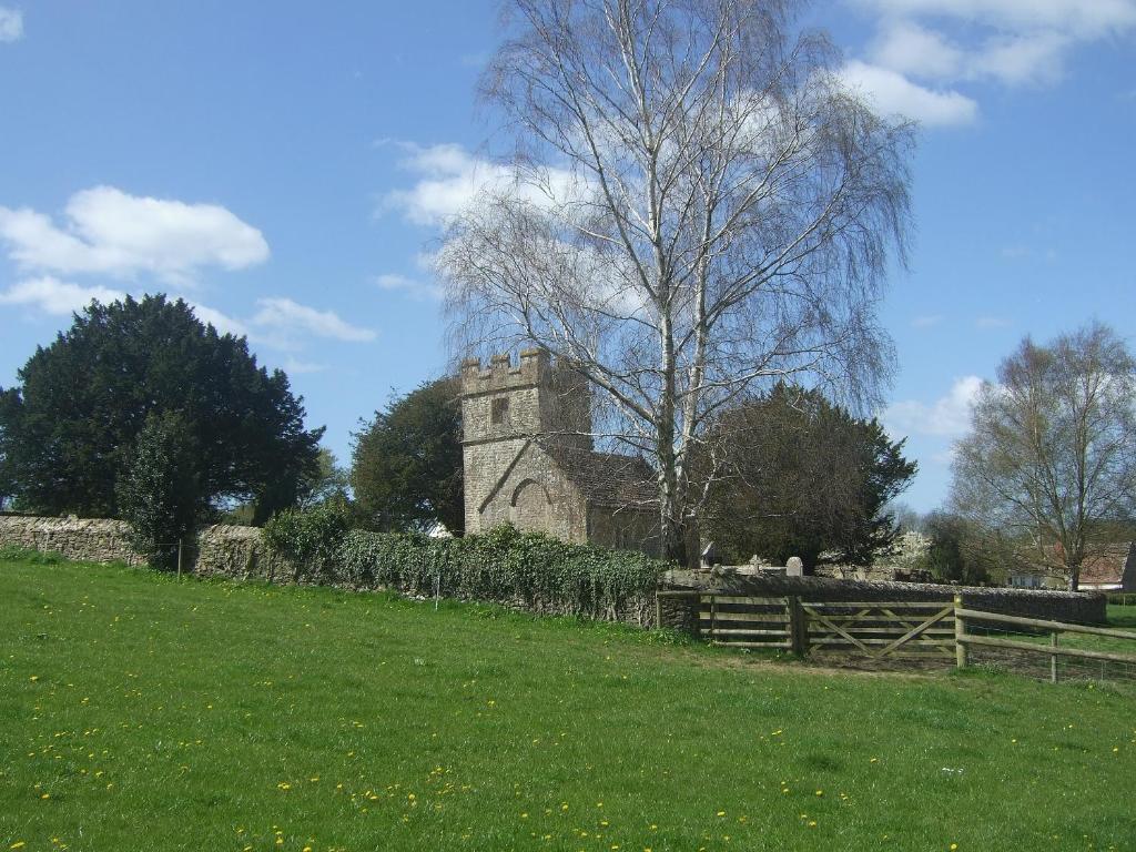 an old stone building in a field with a fence at Buzzards - 8235 in Bridport