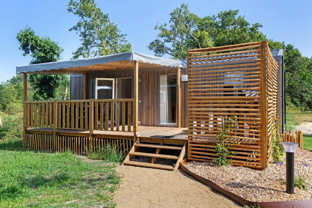 a large wooden cabin with a porch and a staircase at Mobilehome Evasion 46 in Saint-Gervais