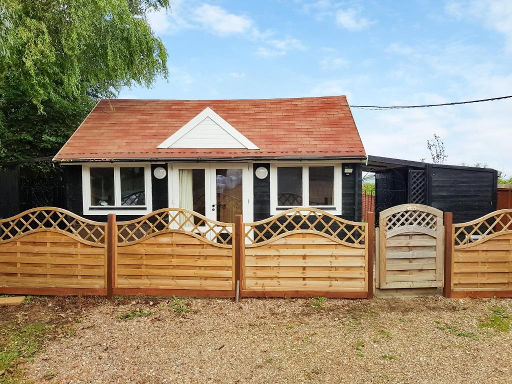 a wooden fence in front of a house at Algwen Cabin in West Walton