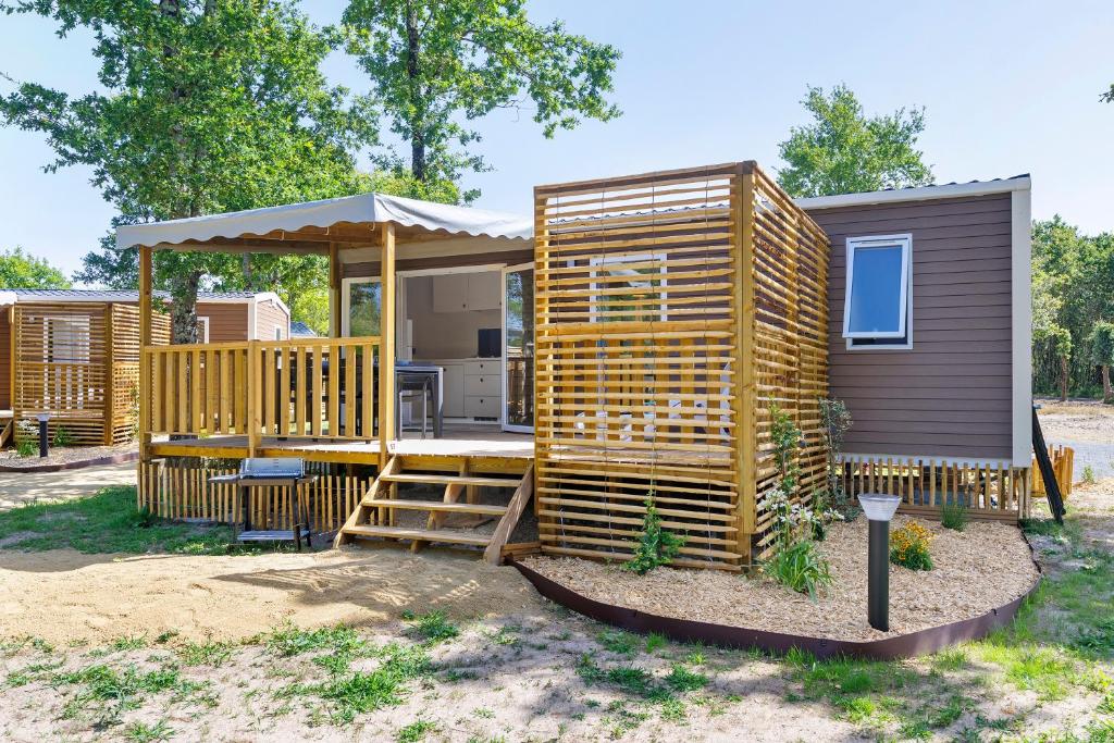 a wooden cabin with a porch and a gazebo at Mobilehome Vallon 57 in Saint-Gervais