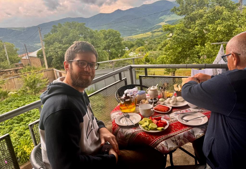 a man sitting at a table with a plate of food at Tatev& Alex BnB in Tatʼev