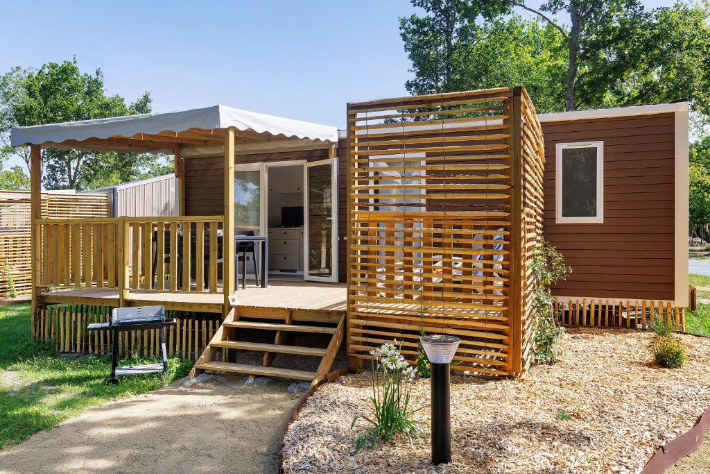 a large wooden cabin with a deck and a gazebo at Mobilehome Vallon 56 in Saint-Gervais