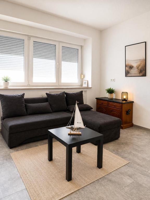 a living room with a black couch and a table at Appartement in Mönchengladbach 2 Zimmer in Mönchengladbach