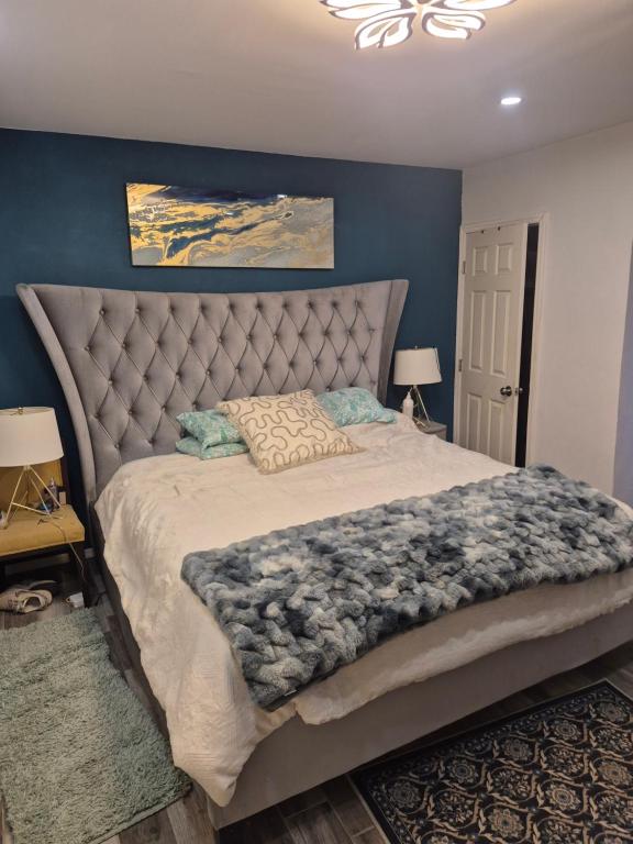 a bedroom with a large bed with a blue wall at La casa de la Playa in Primo Tapia