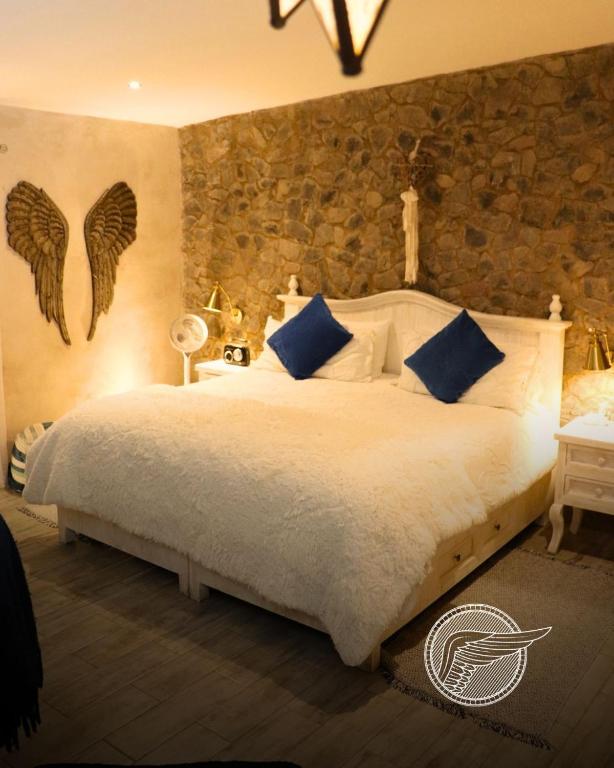 a bedroom with a large white bed with blue pillows at Loft Michelle in Santeagueda