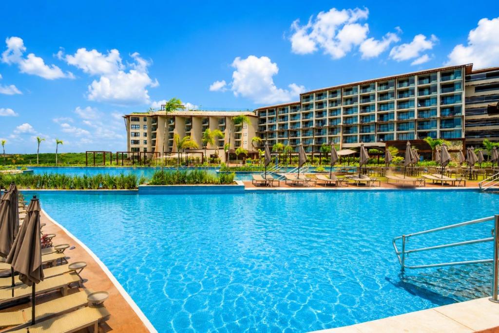 a resort with a large swimming pool with lounge chairs at Tauá Hotel e Convention João pessoa in João Pessoa