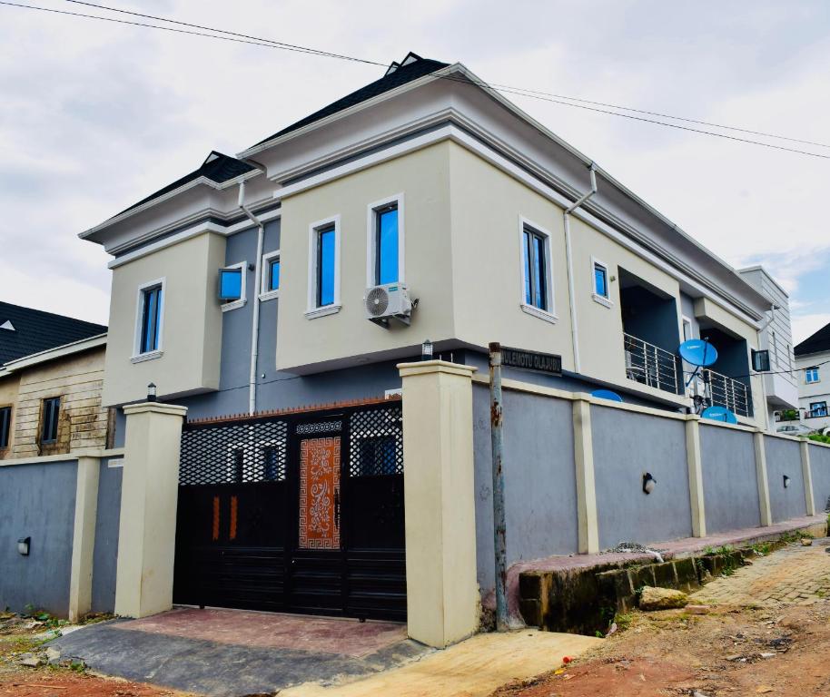 a large white house with a garage at Welcome to Originclicks Apartments! in Ebute Ikorodu