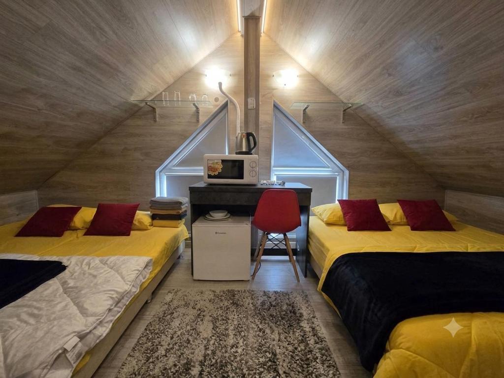 a attic bedroom with two beds and a red chair at Ismail&Stefan in Chişinău