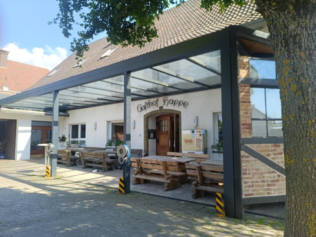 a building with wooden benches in front of it at Gasthof Happe in Harth