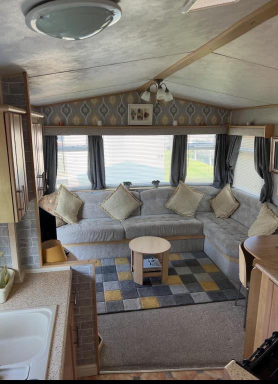 a living room with a couch and a table at Kings Caravan Park A-56 in Chapel Saint Leonards