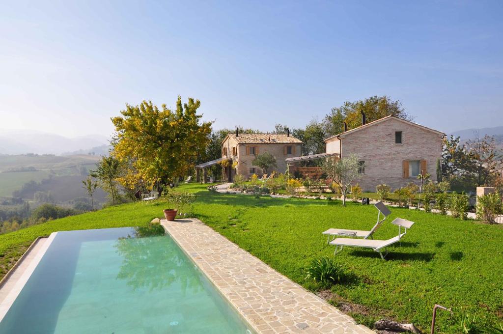 une maison avec une piscine dans une cour dans l'établissement Borgo Farneto, à Montecarotto