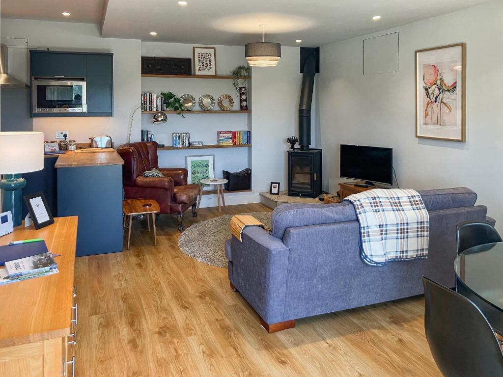 a living room with a blue couch and a tv at Lower Mount Orchard in Stroud