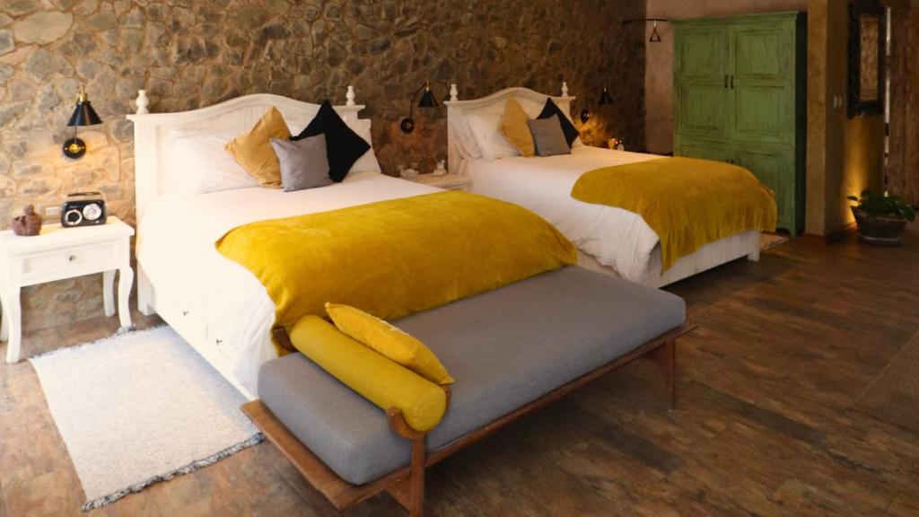 a bedroom with two beds with yellow blankets at Loft Giofiel in Santeagueda