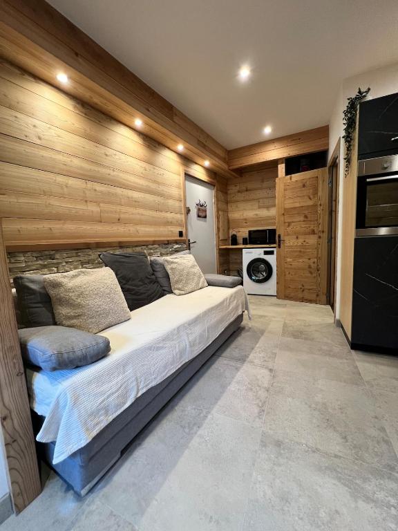 a large bed in a room with wooden walls at Appartement moderne style chalet in Le Monêtier-les-Bains