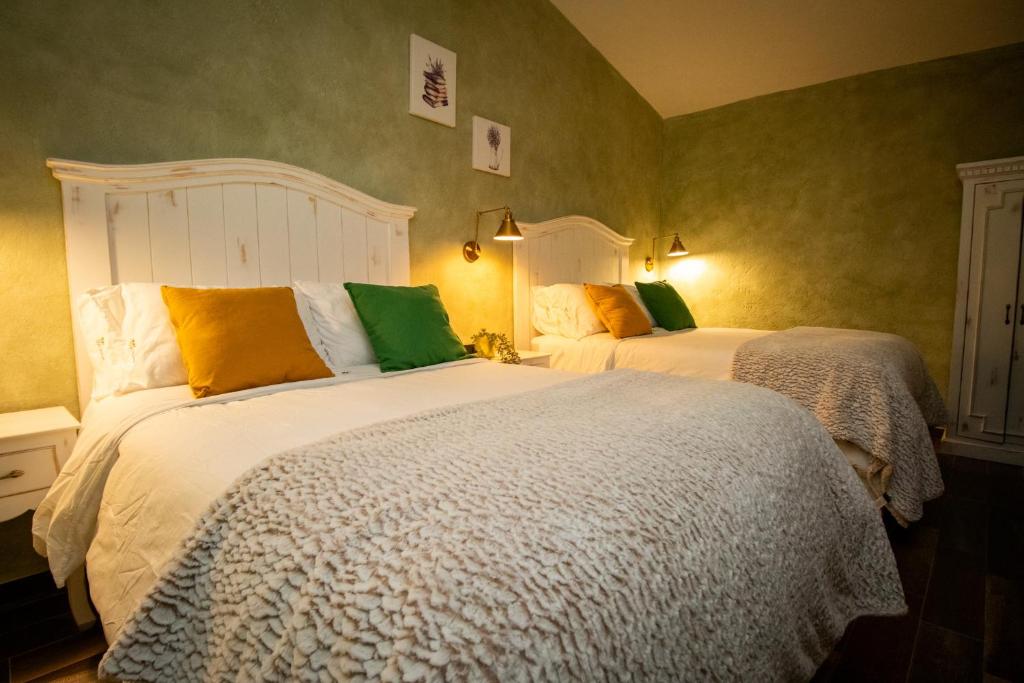 two beds in a bedroom with green walls at Departamento Olivos 4 in Santeagueda