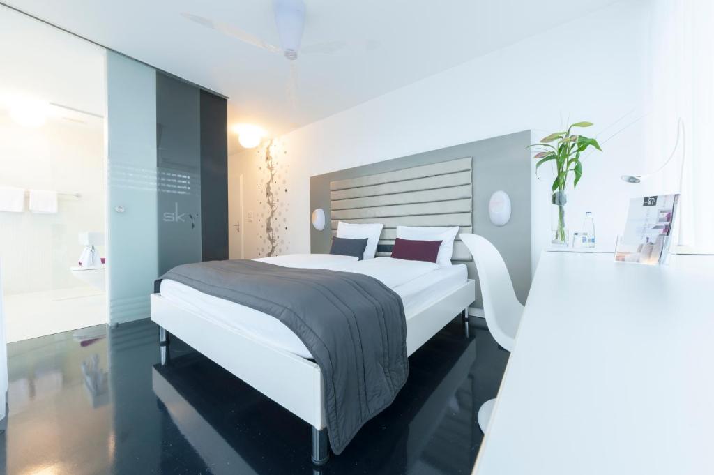 ein Schlafzimmer mit einem großen weißen Bett in einem Zimmer in der Unterkunft Sky Design Motel in Kriessern