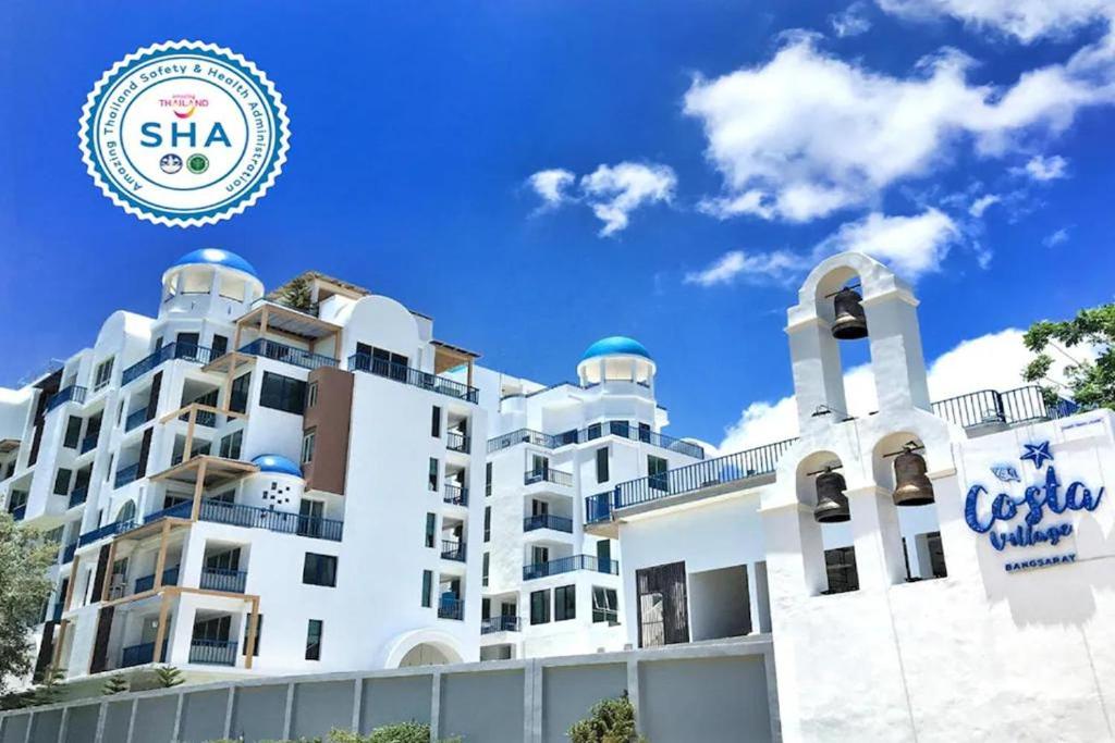 a white building with a sign in front of it at Costa Village Jacuzzi Bangsaray in Bang Sare