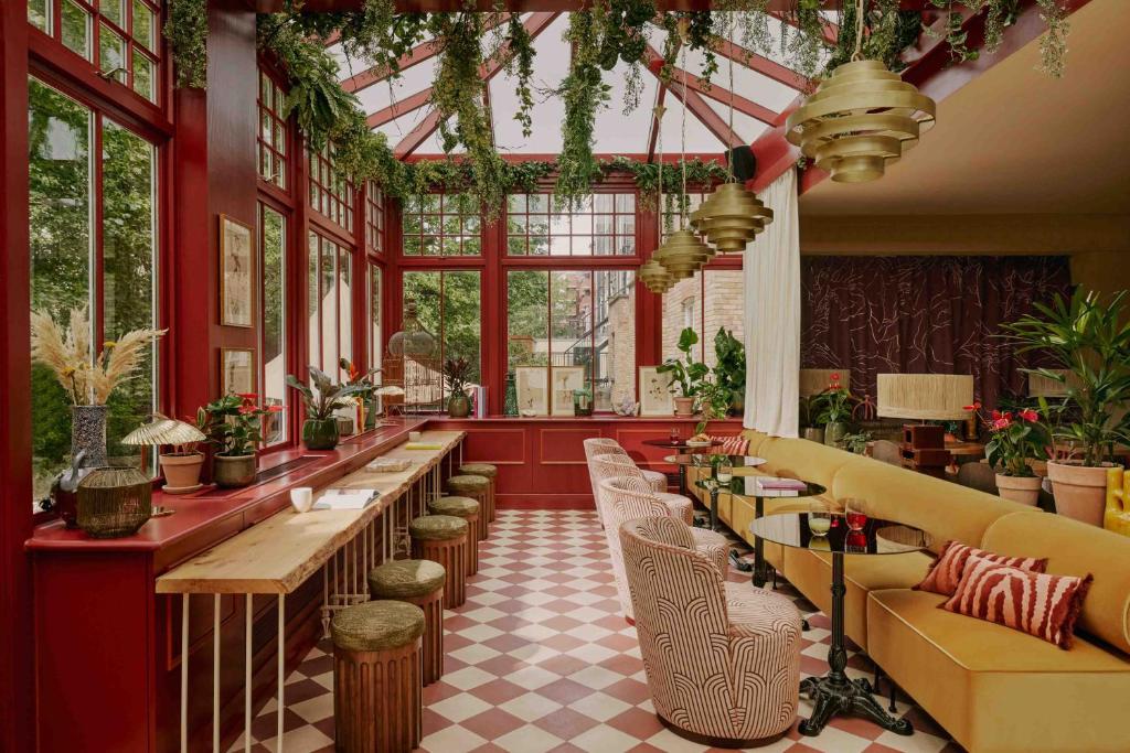 a restaurant with a row of tables and chairs at Ember Locke Kensington in London