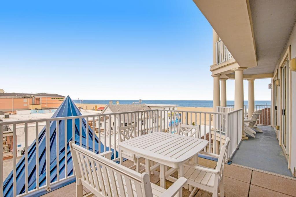 a balcony with a table and chairs and the ocean at Belmont Towers 407 in Ocean City