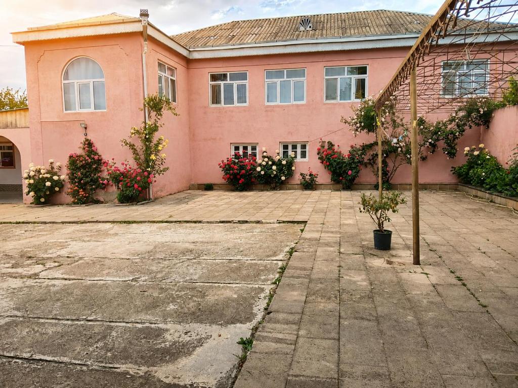 a pink house with flowers in front of it at Qecresh Garden House in Qǝçrǝş