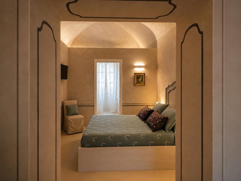 a bedroom with a bed in a room with a window at Castello di Morozzo Guest House in Morozzo